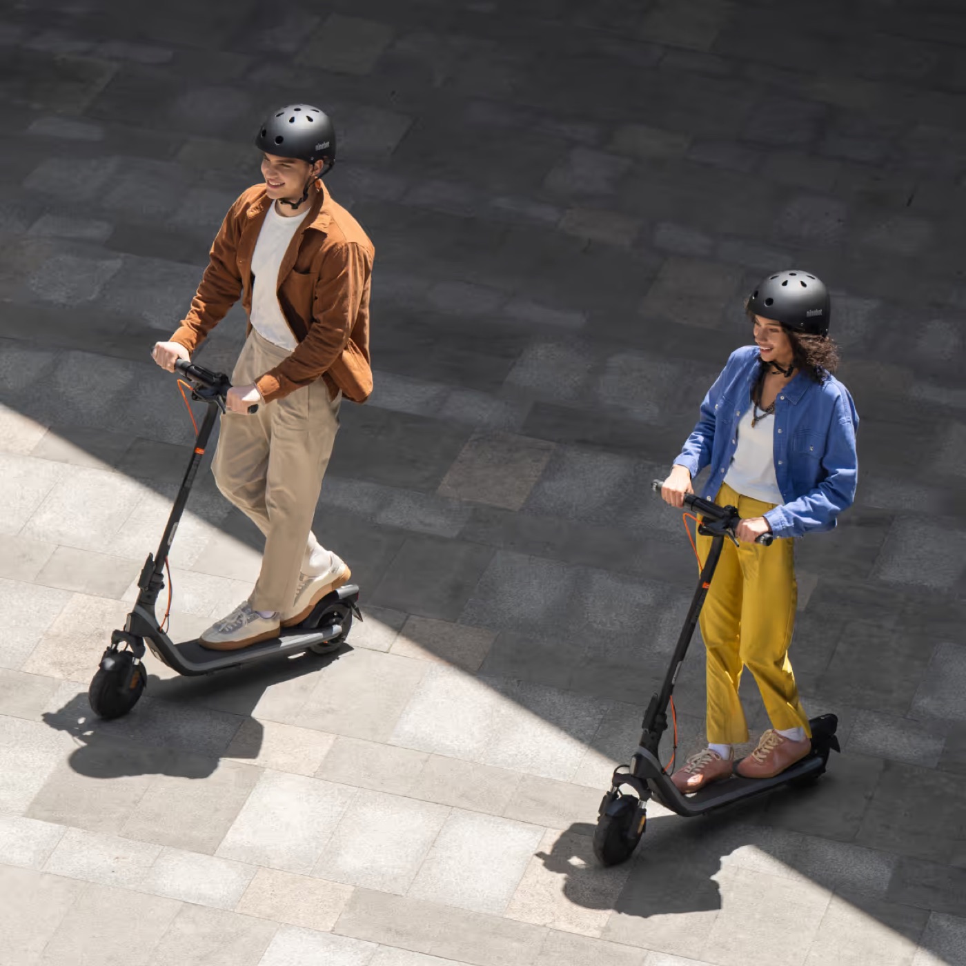 Two people riding Segway Ninebot E2 Plus II electric scooters